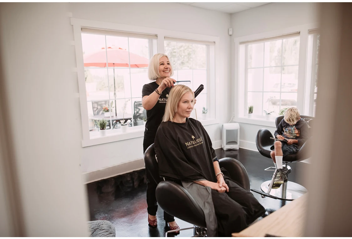 Stylist finishing a client's precision haircut with a flat iron at DaneStyles Hair Artistry in Snohomish, WA